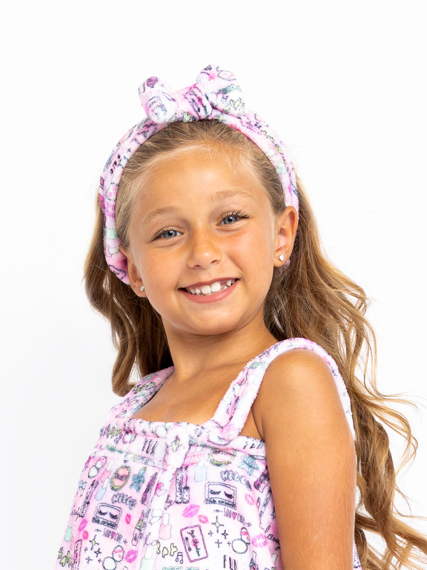 girls pink plush headband with bow with a girly makeup beauty print